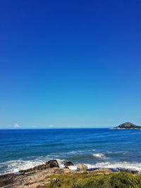 Scenic view of sea against clear blue sky