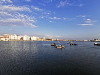 Boats on sea by buildings in city against sky