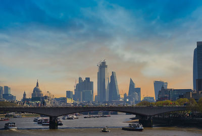 View of bridge and buildings against sky during sunset