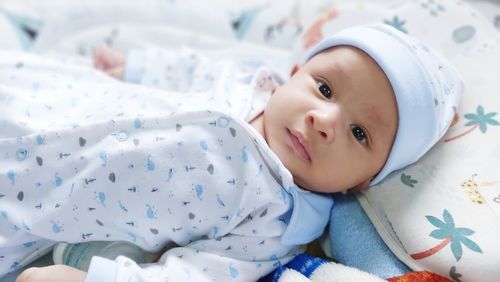 Close-up of cute baby boy sleeping on bed at home