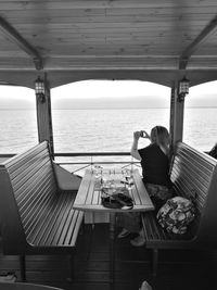 Rear view of woman sitting on boat in sea