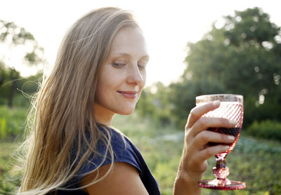 Portrait of a young woman drinking glass