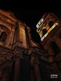 Low angle view of illuminated clock tower at night