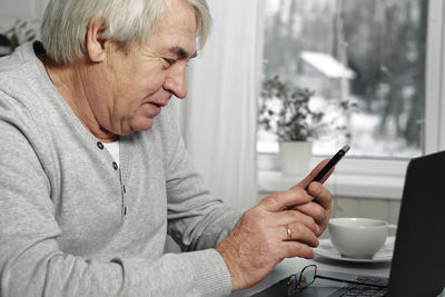 Man using mobile phone while sitting at home