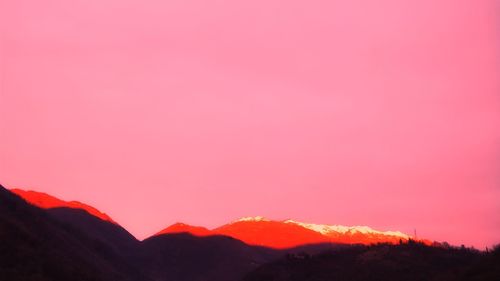 Silhouette mountains against romantic sky at sunset