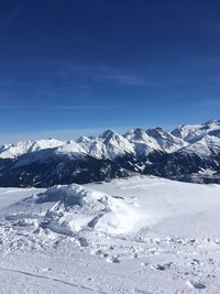 Scenic view of snowcapped mountains against blue sky