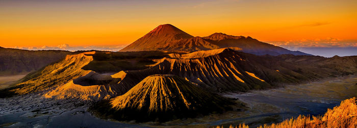 Scenic view of volcanic mountain against sky during sunset