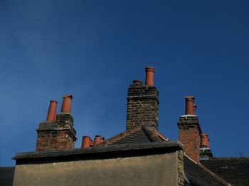 Low angle view of chimney against blue sky