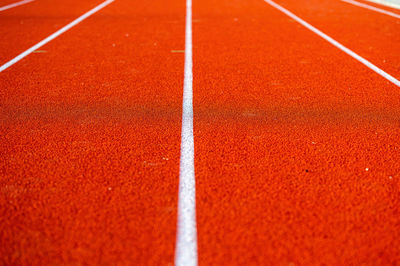 Red runninng race track with border lanes, treadmill at stadium, sport and fitness concept, close-up