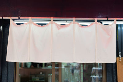 Close-up of clothes drying against white window