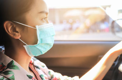 Close-up portrait of cute girl in car