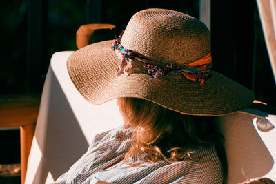 Close-up of woman in hat sitting on chair