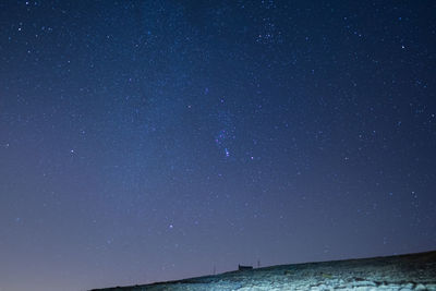 Scenic view of sea against star field at night