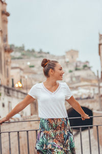 Woman standing by railing against blurred background