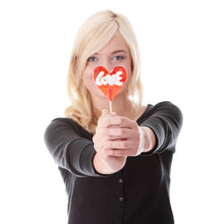 Portrait of woman holding heart shape over white background