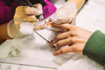 Cropped hand of beautician doing manicure