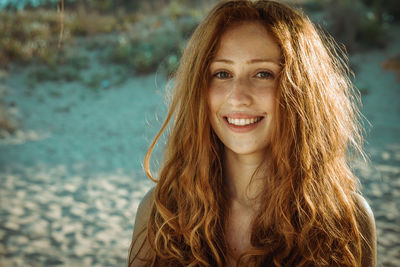 Portrait of smiling young woman against sea