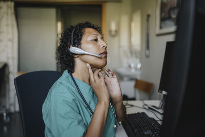 Female doctor giving advice through video call while sitting in hospital