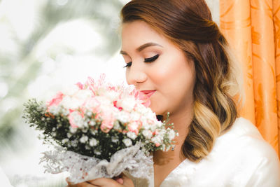 Portrait of beautiful woman by flower bouquet