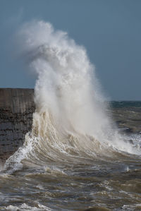 Waves crashing against a sea defence harbour wall at newhaven in east sussex