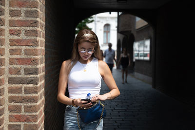 A young woman is nervously looking for something in her handbag person