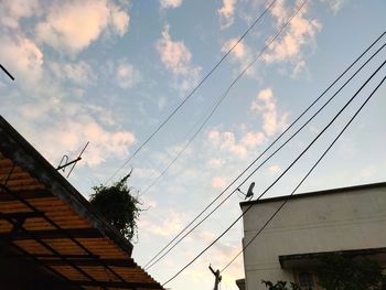 Low angle view of cables against sky during sunset