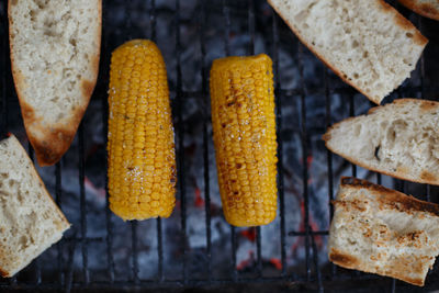 Corn cobs put on the barbecue with bread on a summer holiday