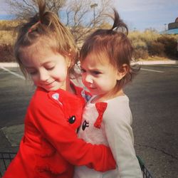Close-up of cute siblings embracing on road