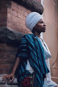 Young woman standing against built structure