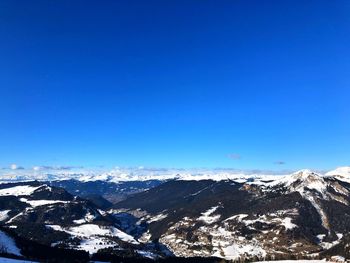 Scenic view of snowcapped mountains against clear blue sky