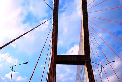 Low angle view of suspension bridge against sky