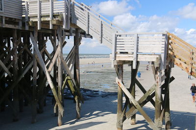 Pier on sea against cloudy sky