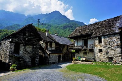 Houses by road amidst buildings against sky