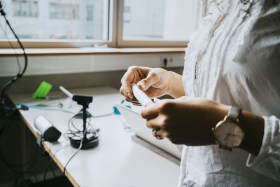 Midsection of teacher holding felt tip pen at college classroom