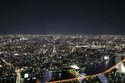 Illuminated buildings in city against sky at night