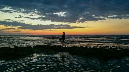 Silhouette of people on beach at sunset