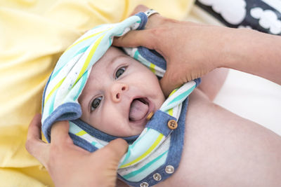 Overhead view of mother dressing baby boy at home