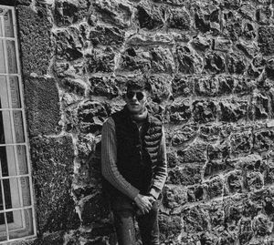 Portrait of young man standing against wall
