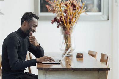 Young entrepreneur working on laptop while sitting at cafe