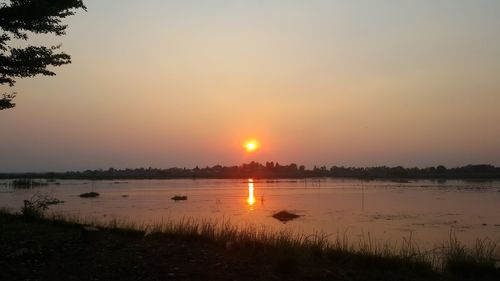 Scenic view of lake against sky during sunset