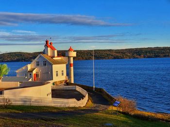 House by sea against blue sky