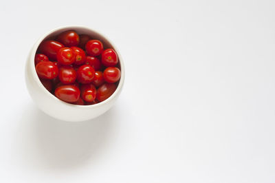 Close-up of tomatoes in bowl against white background