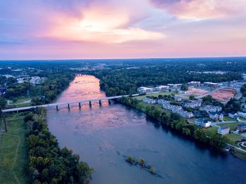 High angle view of river amidst buildings in city during sunset