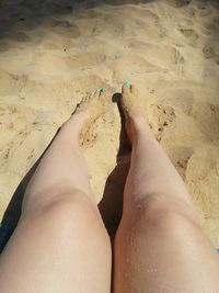 Low section of woman relaxing on beach