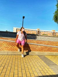 Full length of woman with umbrella against sky