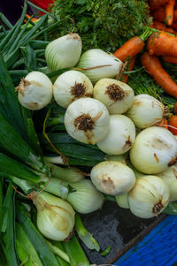 White onions with fresh leaves in a popular urban open-air market
