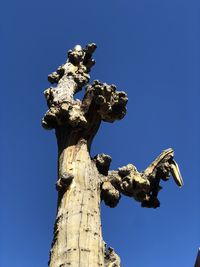 Low angle view of angel statue against clear blue sky