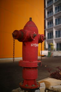 Red fire hydrant by building in city