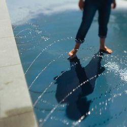 Low section of woman standing in fountain