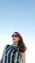 Portrait of woman wearing sunglasses against clear sky